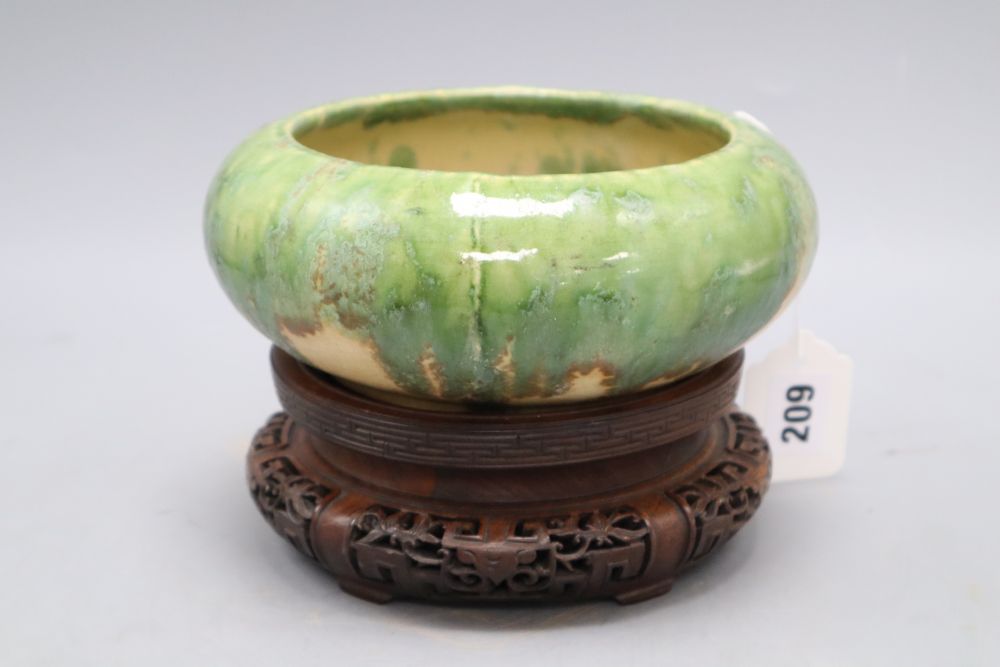 A Chinese green and straw-coloured crackle glaze brushwasher, Qing dynasty hongmu stand, height 13cm overall